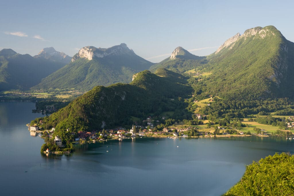 Bewaldete Bergrcken und Felsen am Lac d'Annecy leuchten in der M